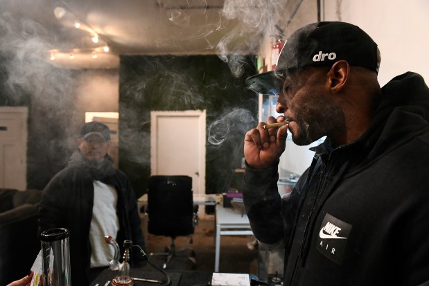 Owner Dewayne Benjamin smokes at his ...