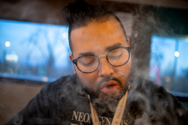 David Medina exhales smoke after taking ...