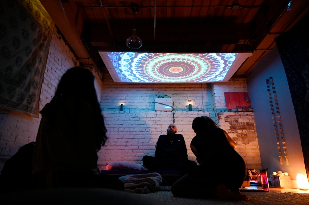 A Sacred Tribe attendee, center, sits ...