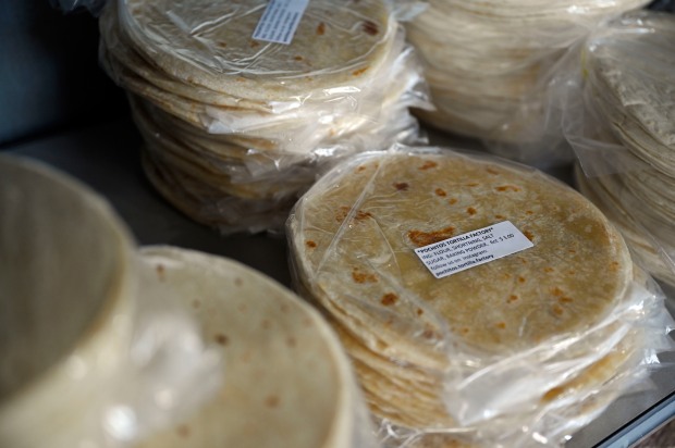Flour tortillas sit on shelves for ...