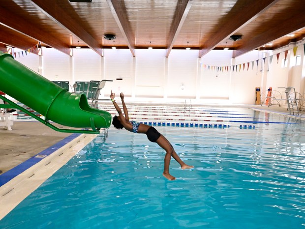Celeste Leonard, 14, drops into the deep end of the pool from the slide at the Hiawatha Davis Jr. Recreation Center in Denver Friday, June 21, 2024. (Photo by Andy Cross/The Denver Post)